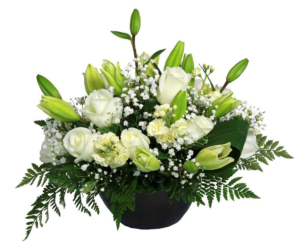 A fresh arrangement with white roses, lilies, greens and fillers.