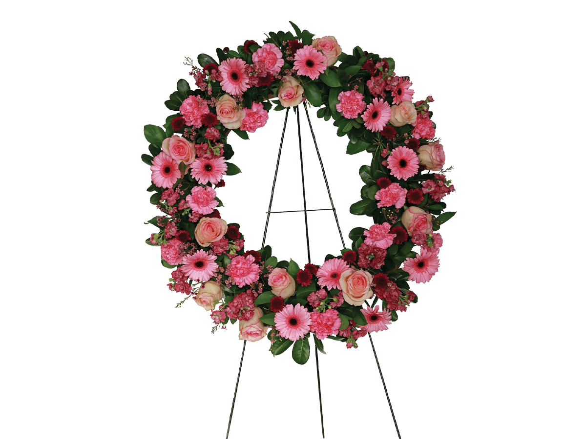 A tribute wreath with pink gerberas, carnations, chrysanthemums and greens.