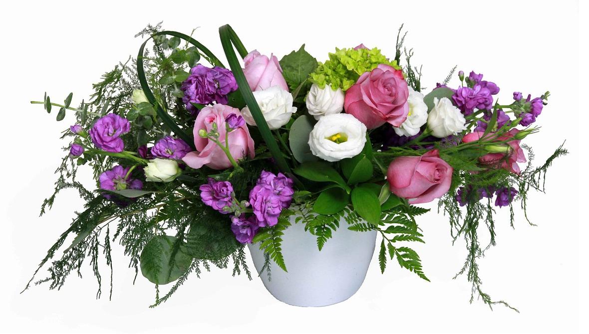 A fresh arrangement with pink and white roses, purple lisianthus and hydrangea, greens and fillers.